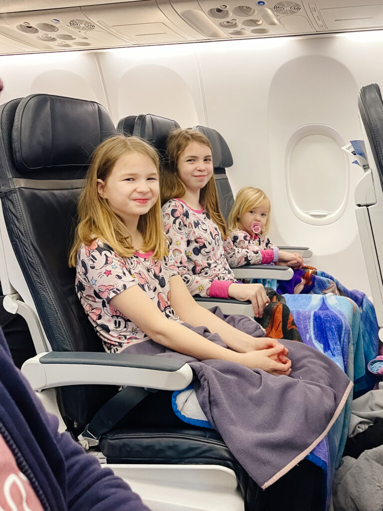 Money-saving tips for Disney for flights, three matching girls on Alaska airline plane