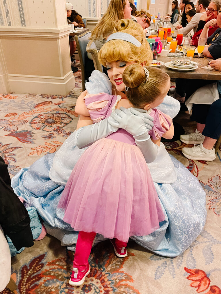 5 year old girl hugging Cinderella during character dining experience in Walt Disney World