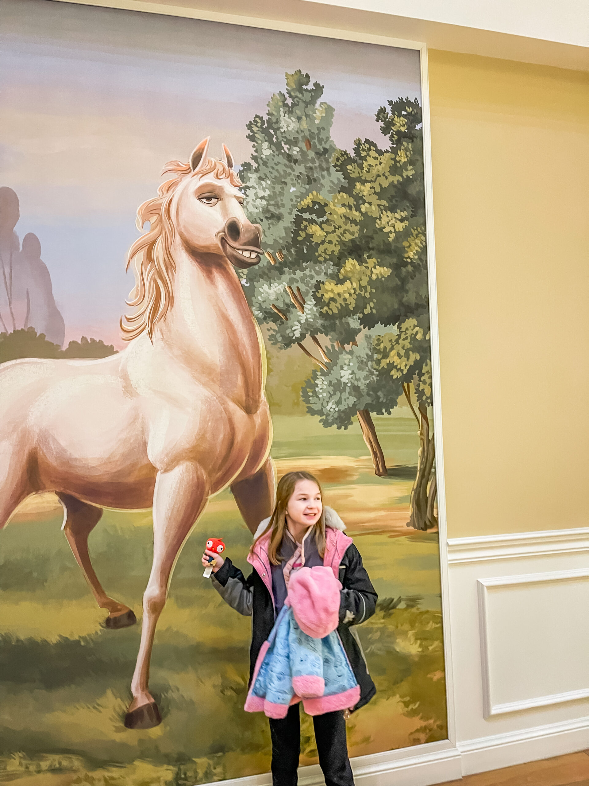 Girl standing by Maximus painting in Disney World's Saratoga Springs Resort Lobby