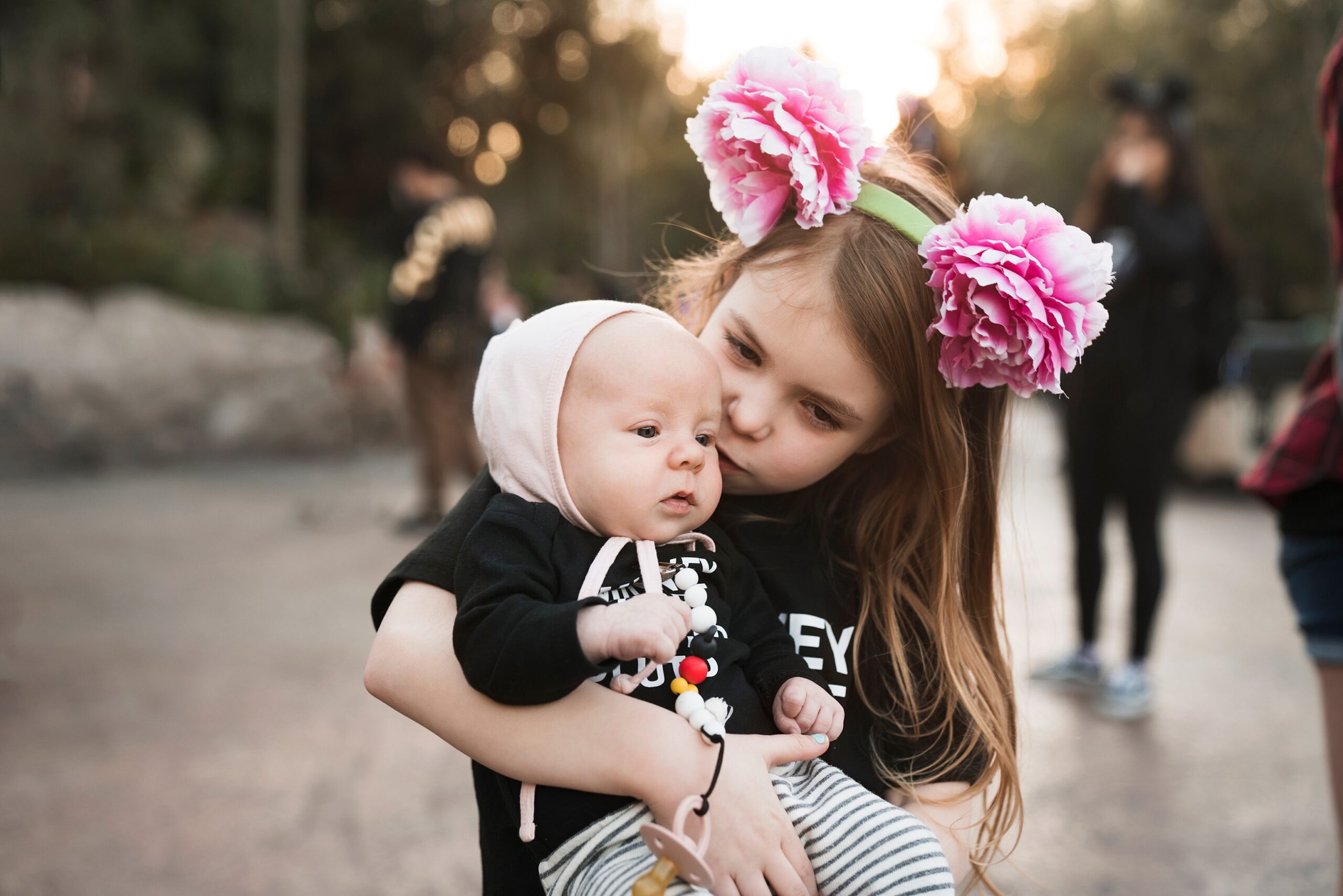 Big sister with newborn baby in Disneyland